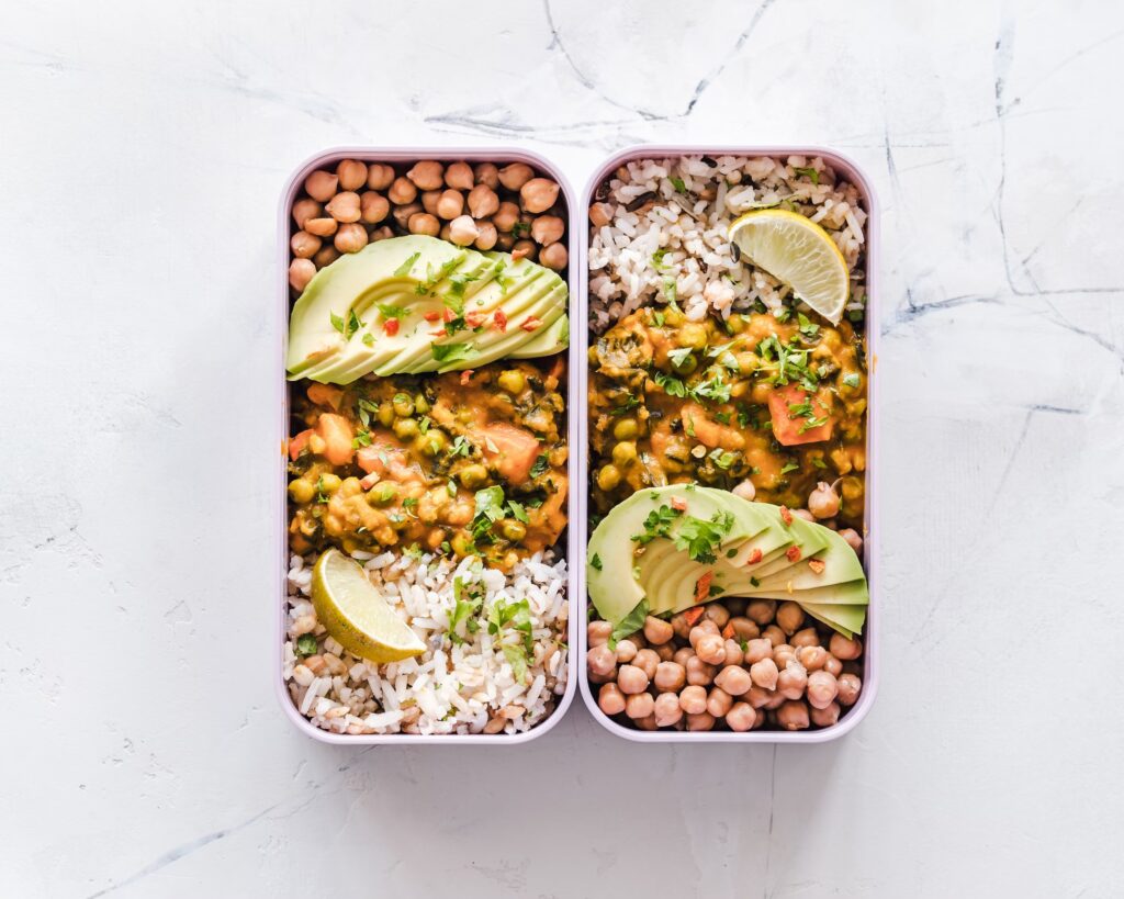 bento box lunch with avocado, chickpeas, chicken, and rice
